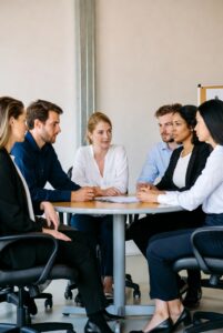 Team of executives sitting at round table discussing label issues