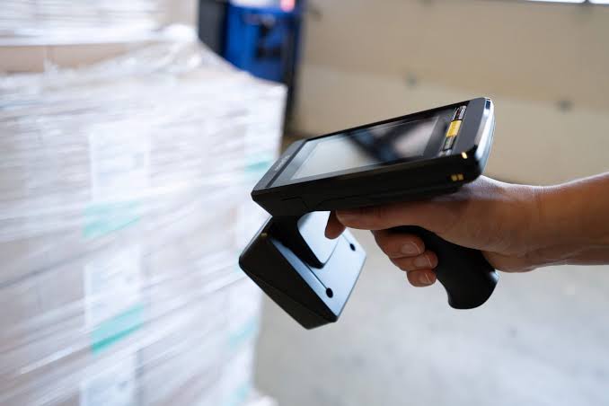 Handheld scanner reading an RFID tag through packaging